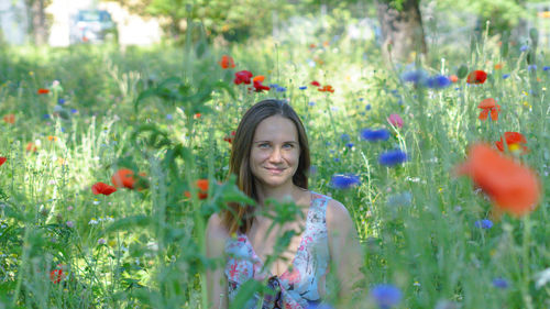 Portrait of smiling girl on flowering plants at field