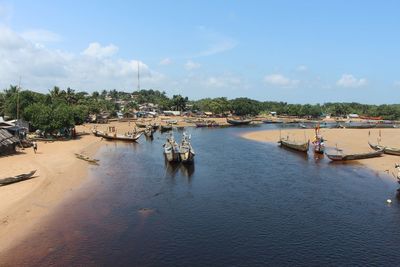 Boats moored at harbor against sky