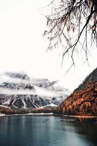 Scenic view of river by mountains against clear sky