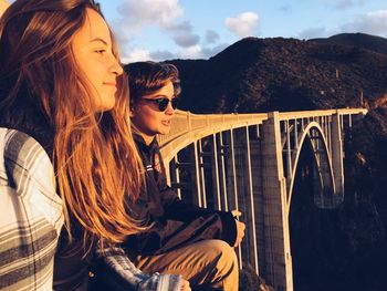 Young women sitting by bixby bridge