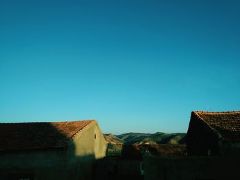 Low angle view of houses against clear blue sky