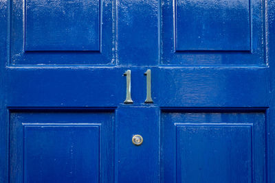 House number 11 on a blue wooden front door in london 