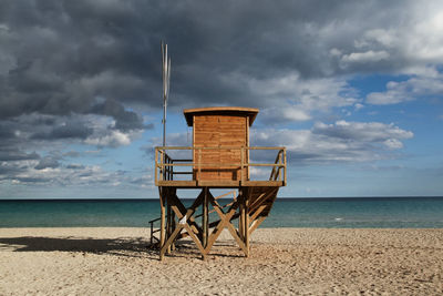 Lifeguard hut on beach against sky