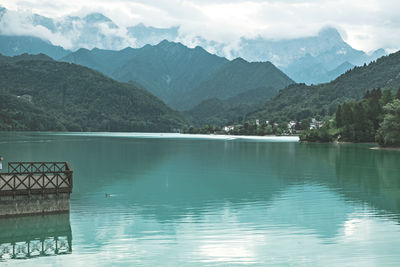 Scenic view of lake by mountains against sky