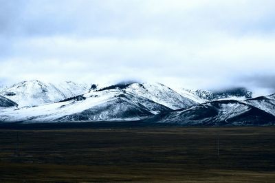 Scenic view of snow covered mountains against sky