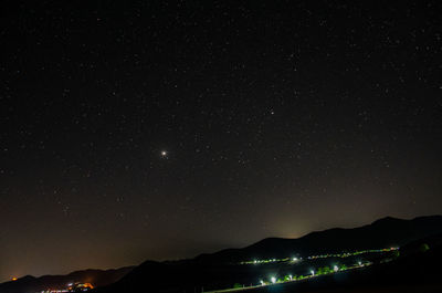 Scenic view of silhouette mountains against sky at night