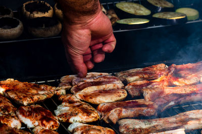 Close-up of person preparing food on barbecue grill