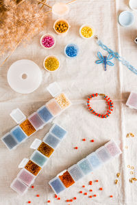 Items for beading - boxes with beads, thread and scissors on the table. 