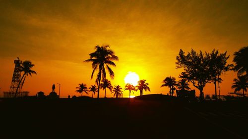 Silhouette palm trees against sky during sunset