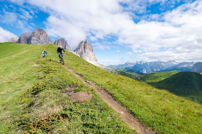 Low angle view of people riding bicycles on mountain