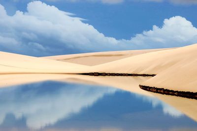 Scenic view of desert against cloudy sky