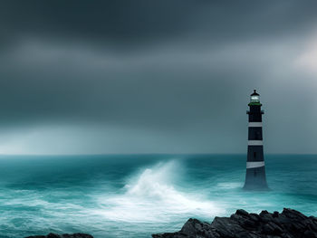 Lighthouse by sea against sky