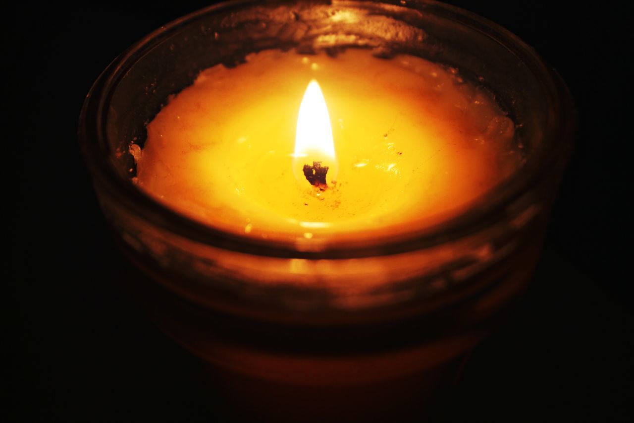 CLOSE-UP OF ILLUMINATED TEA LIGHT CANDLE