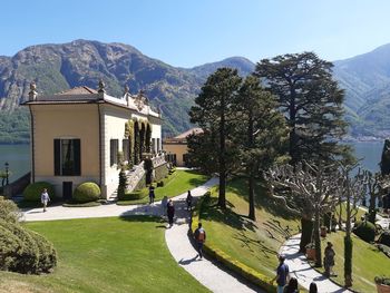 People walking on road by mountain against sky
villa del balbianello