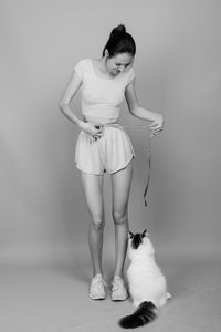 Full length of teenage girl standing against white background