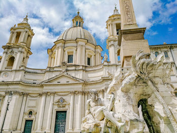 Low angle view of statues on building against sky