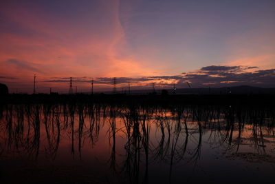 Scenic view of dramatic sky over lake during sunset