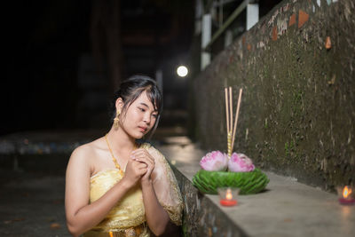 Portrait of young woman sitting on table