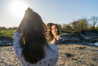 Portrait of beautiful woman on beach against sky