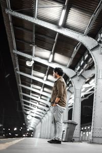 Low angle view of man standing at railroad station platform