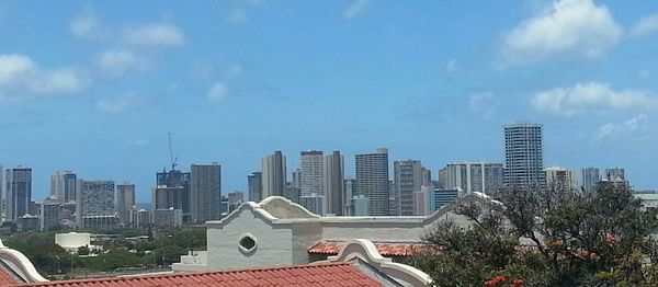 Buildings in city against cloudy sky