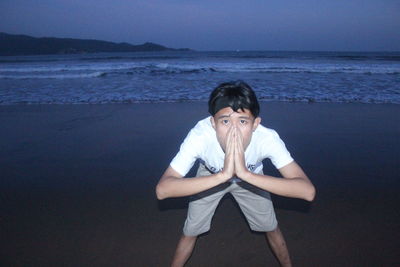 Portrait of young man standing at beach