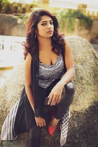 Portrait of young woman sitting on rock