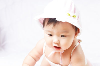 Cute baby girl crawling on bed at home