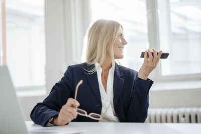 Businesswoman using cell phone in office