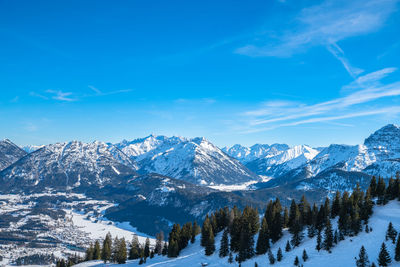 Scenic view of snowcapped mountains against blue sky