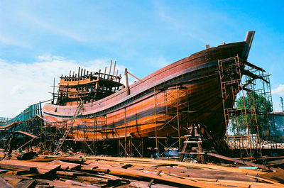 Low angle view of abandoned ship against sky