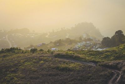 Scenic view of field against sky during foggy weather