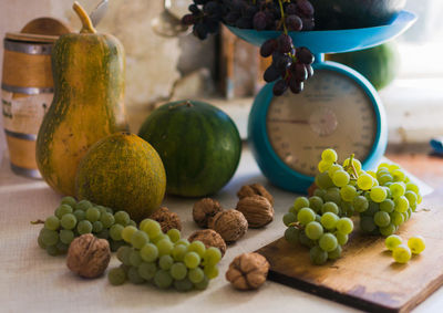Autumn still life with pumpkins,walnuts,melons, watermelon and grapes on a scale to scale