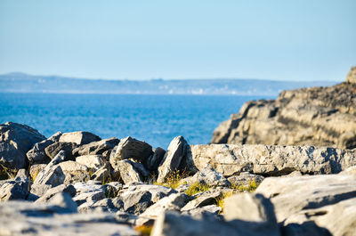 Rocks on beach against blue sky