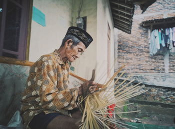 Young man sitting outside building