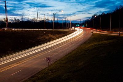 Road passing through landscape against cloudy sky