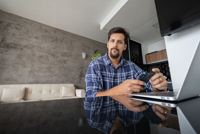 White man working at home with laptop on desk. home office. gray notebook