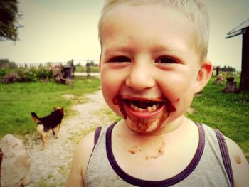 Portrait of cute boy laughing with chocolate on his face