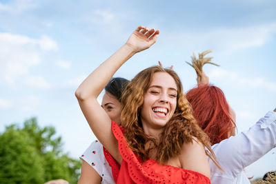 Cheerful girls dancing on the background of the sky