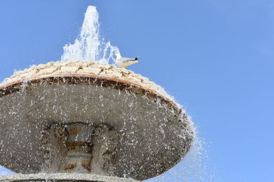 Low angle view of ice against clear blue sky