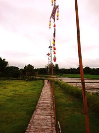 View of railroad tracks on field against sky