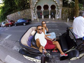 Couple taking selfie while traveling in pedicab