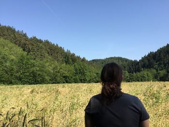 Scenic view of grassy field against blue sky