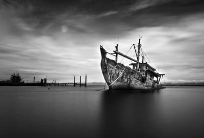 Fishing boat in sea against sky