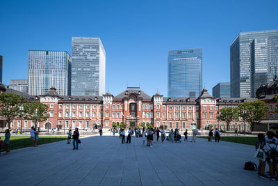 Tokyo station in tokyo, japan on a sunny  day with skyscrapers in the background 