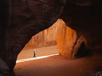 Woman walking under an arch. 