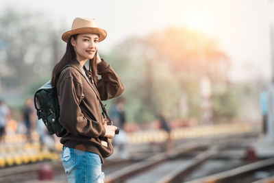 Portrait of young woman standing against sky during sunset