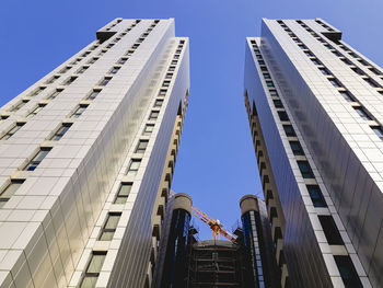 Low angle view of modern buildings against clear blue sky