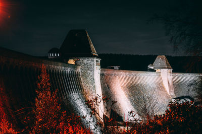 Built structure by building against sky at night