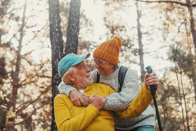 Rear view of woman wearing hat standing in forest